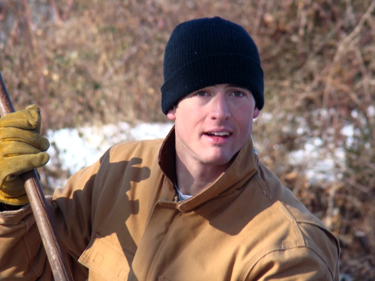 a man in the snow with a wooden stick