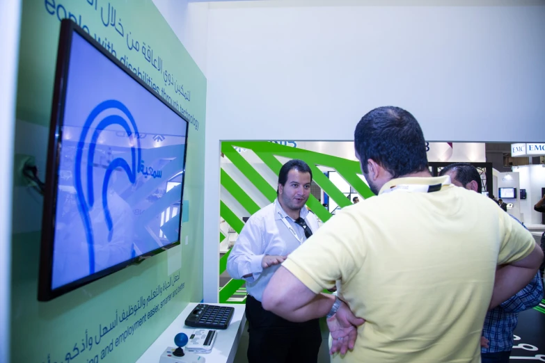 two men standing around at an electronics show