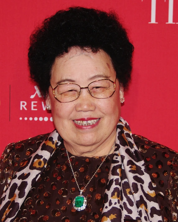 a lady smiling for the camera with a necklace on her neck