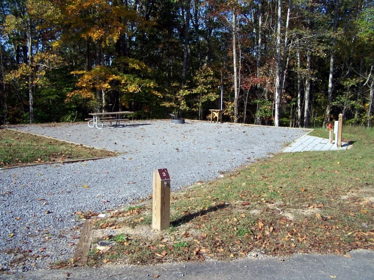 a small wooden out block in front of some trees