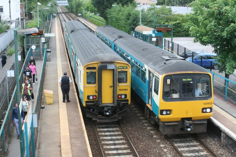 two trains passing each other on the tracks at a train station