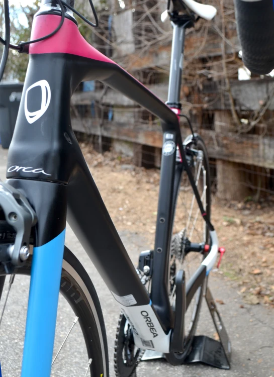 a bicycle parked on a street next to a wooden fence