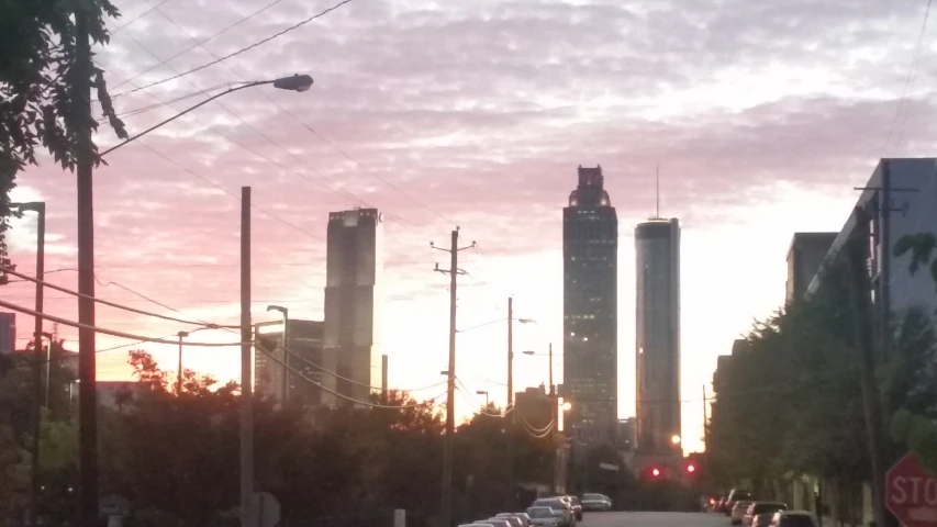 the sun is setting over some tall buildings