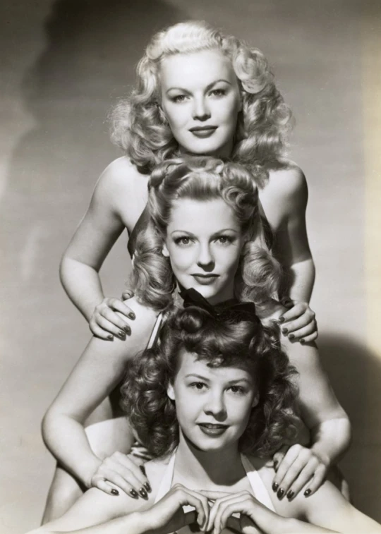 three young women are posed with each other