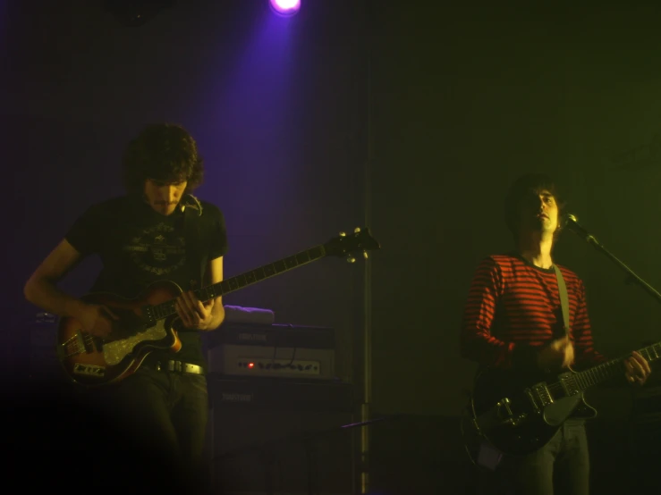 a young male and female on stage with guitar