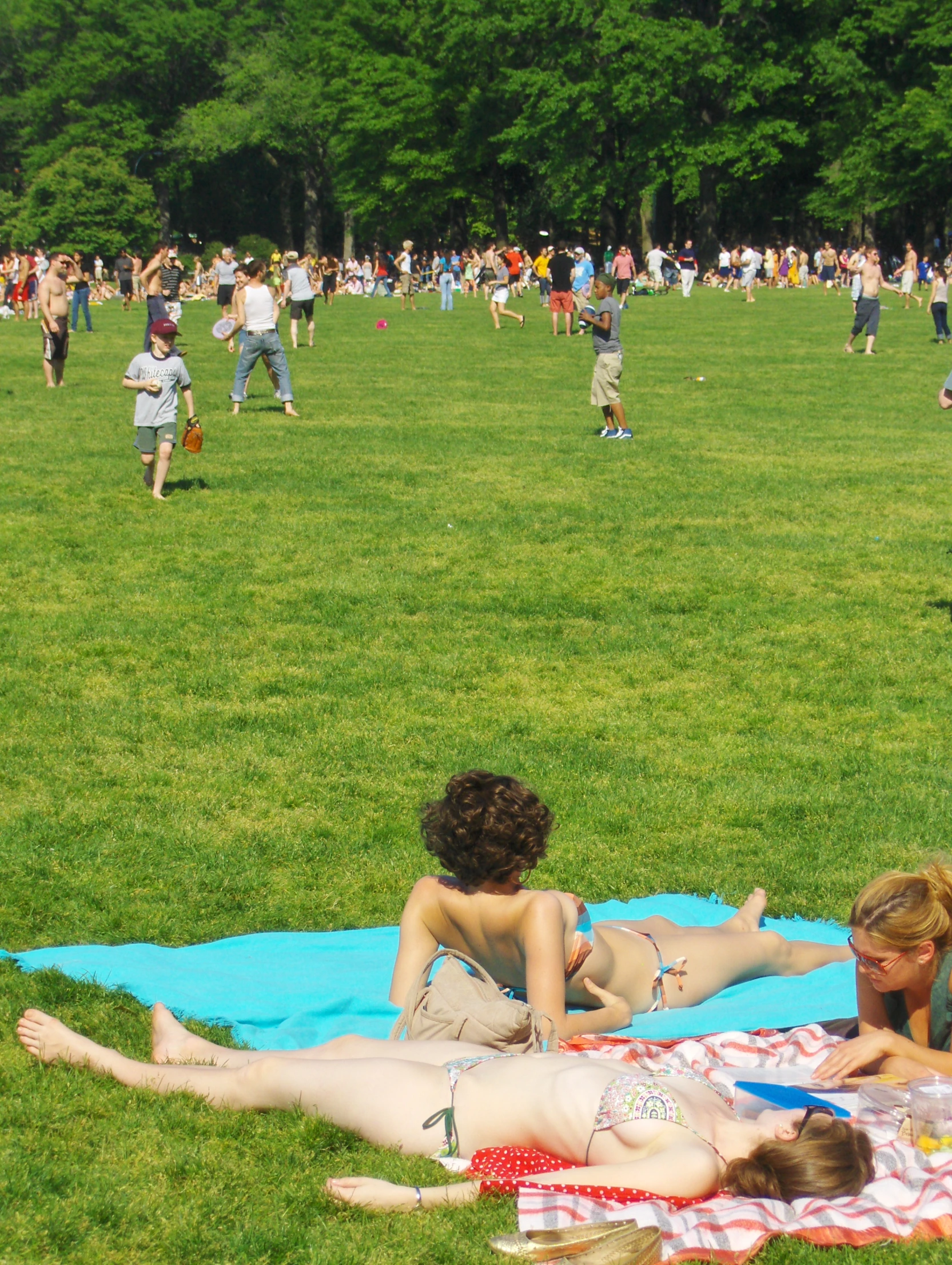 two girls laying on the grass with their feet crossed