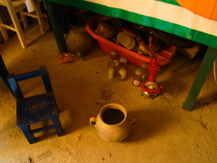 a small vase with an orange stripe is under a green table