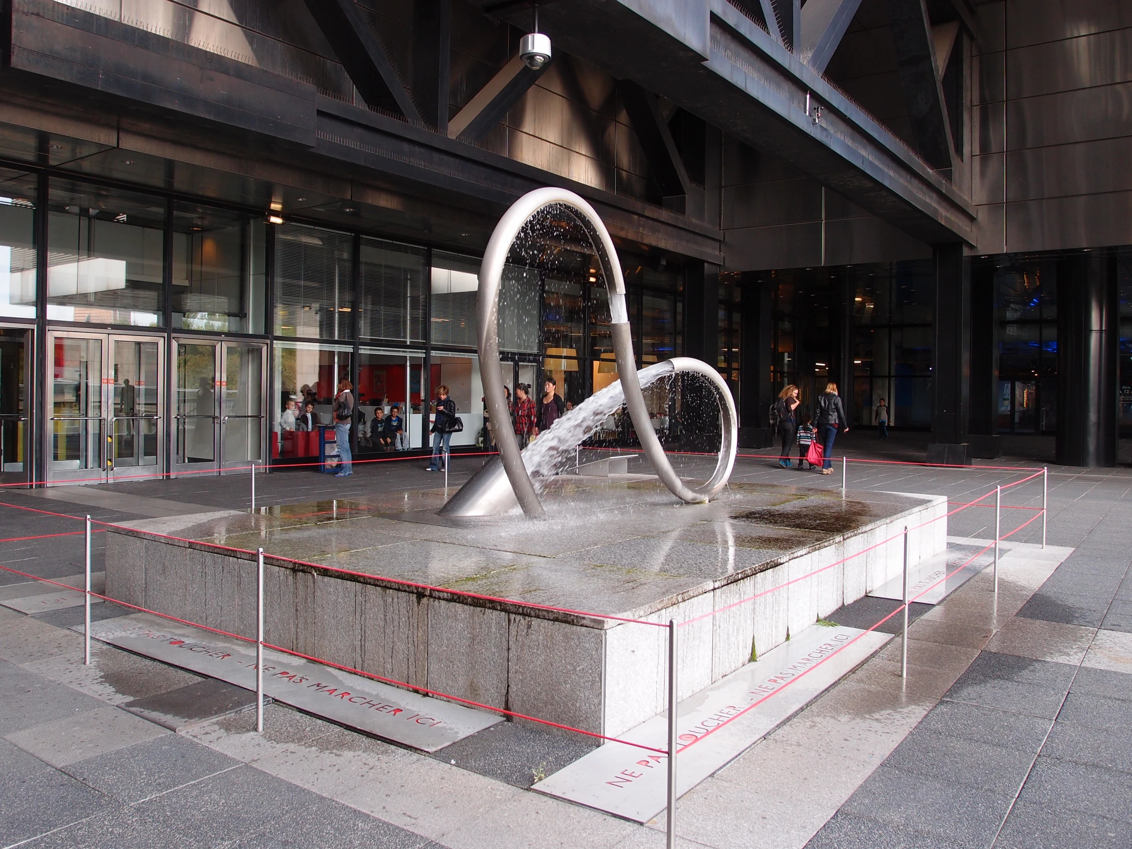 there is a sculpture of two shapes on a pedestal in front of the building
