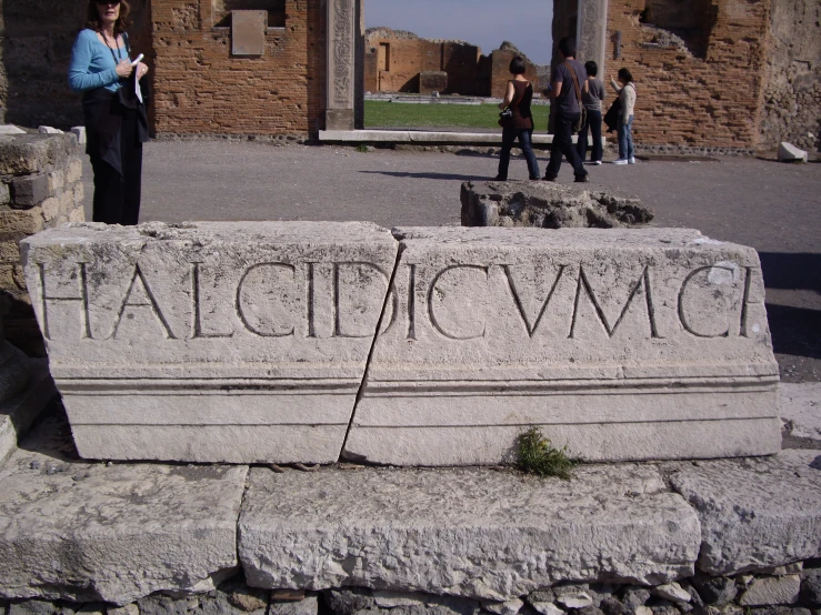 several people standing around some of the ruins that make up an archeological site