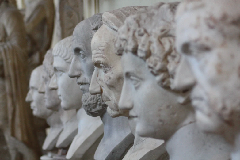 an image of many heads of ancient statues