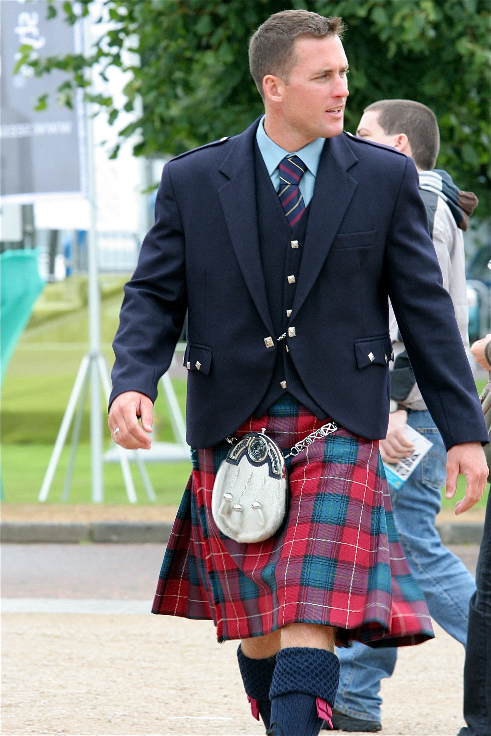 a man in a kilt is walking across the street