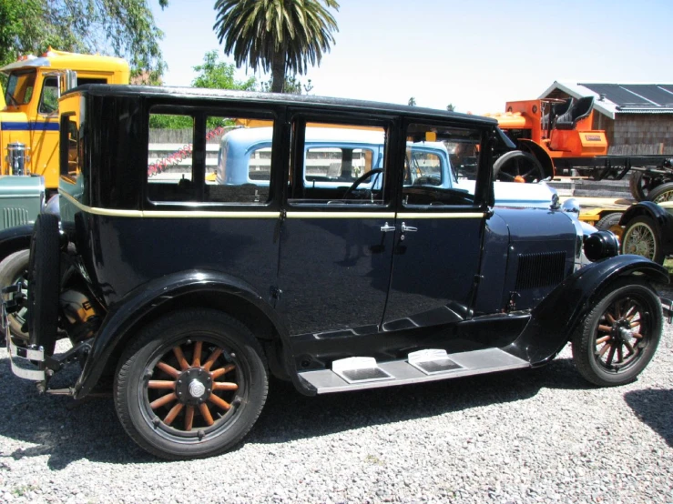 an old model black car parked near other antique cars