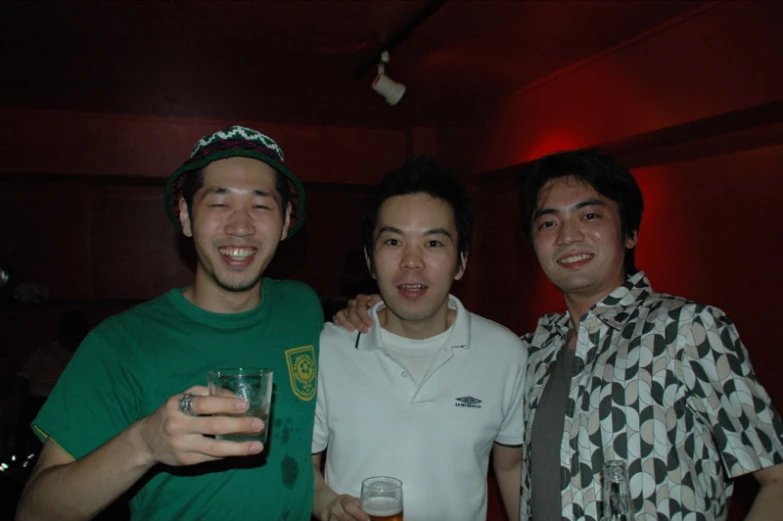 three men standing next to each other holding glasses