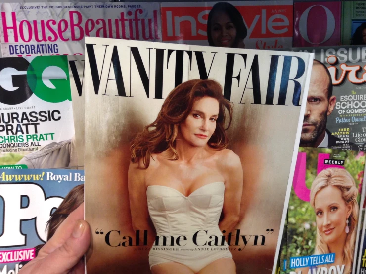 woman holding magazines with various covers in her hand