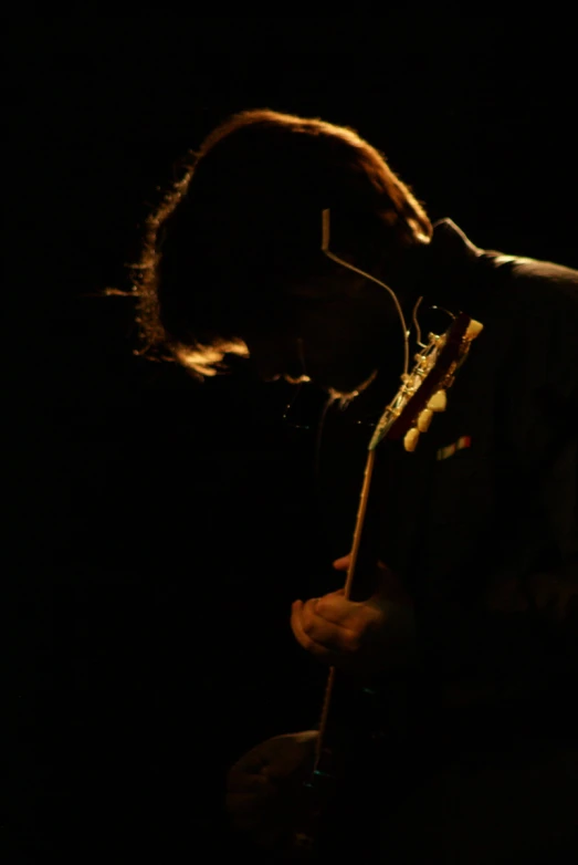 a man holding a guitar standing next to a microphone