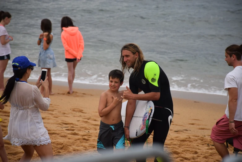 surfer with children playing in the sand and on the beach