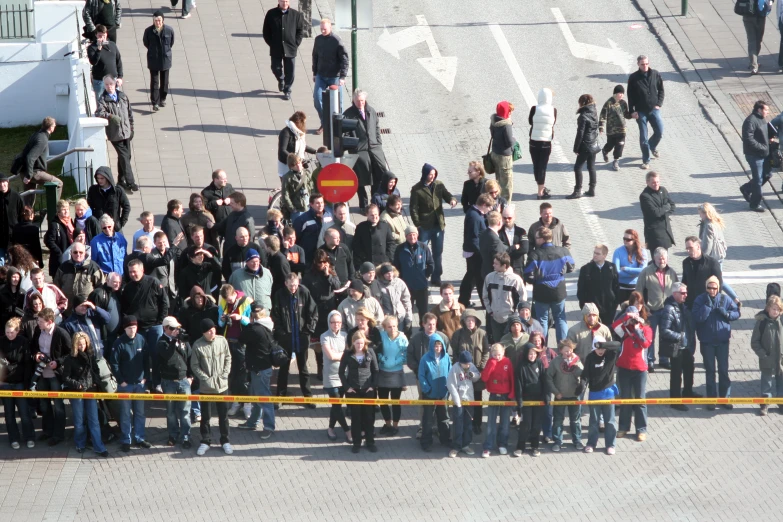 a group of people are standing outside by a fence