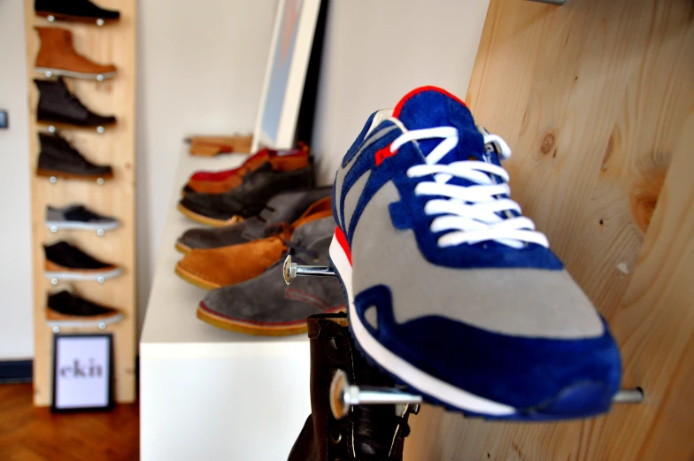 several pairs of shoes sitting on display and hanging on the wall