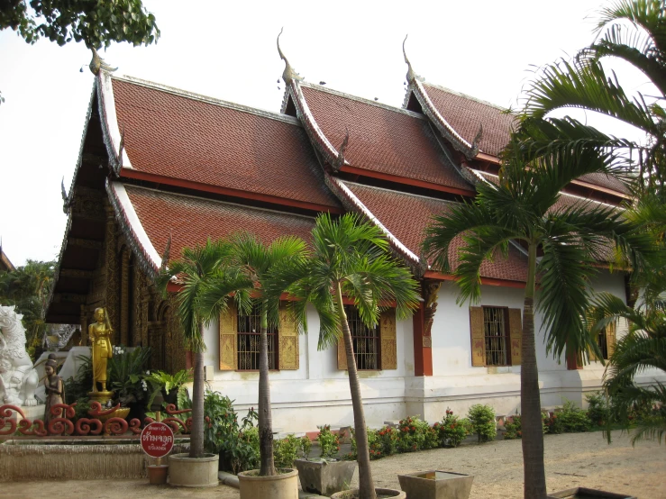 a building with many tall windows and palm trees