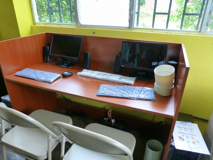 two chairs and a table with computer monitors