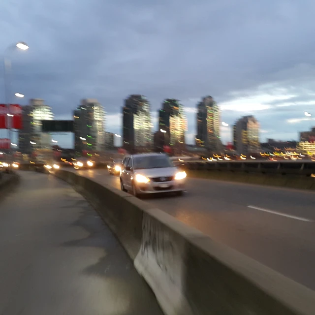 a road full of cars and street lights in front of a city