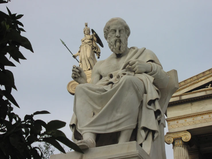 statue of jesus sitting on the base of a monument