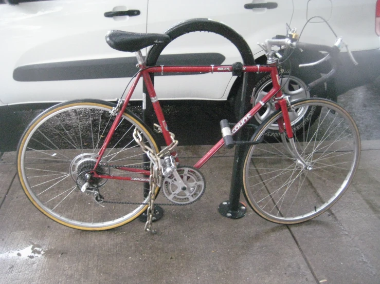 a bike is parked beside a black car