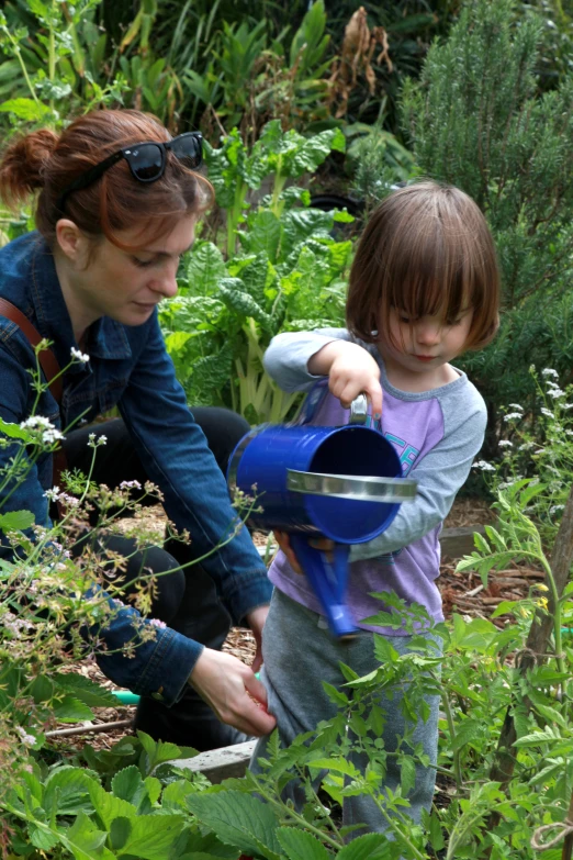 mother and child in a garden tending to plants