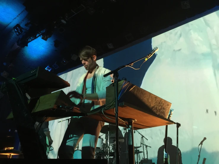 man on stage at outdoor concert with large projection