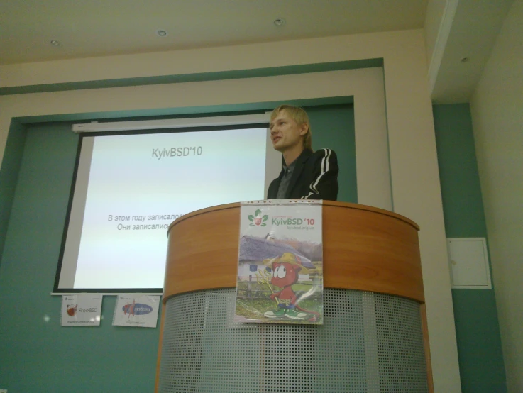 the woman is talking at a podium in front of a projector screen