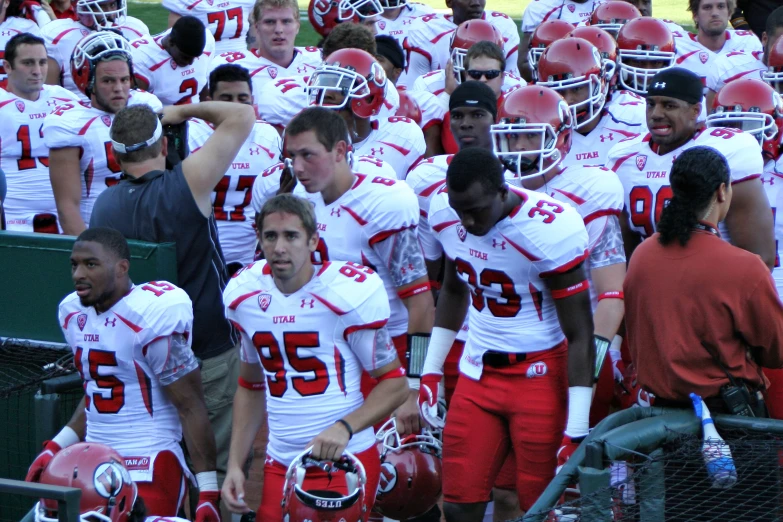 football players wearing red and white are gathered in a stadium