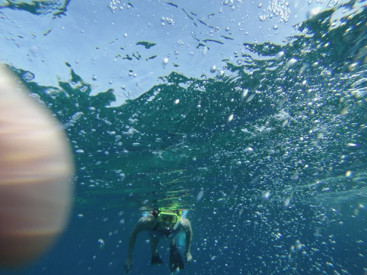 a man diving underwater while holding a camera