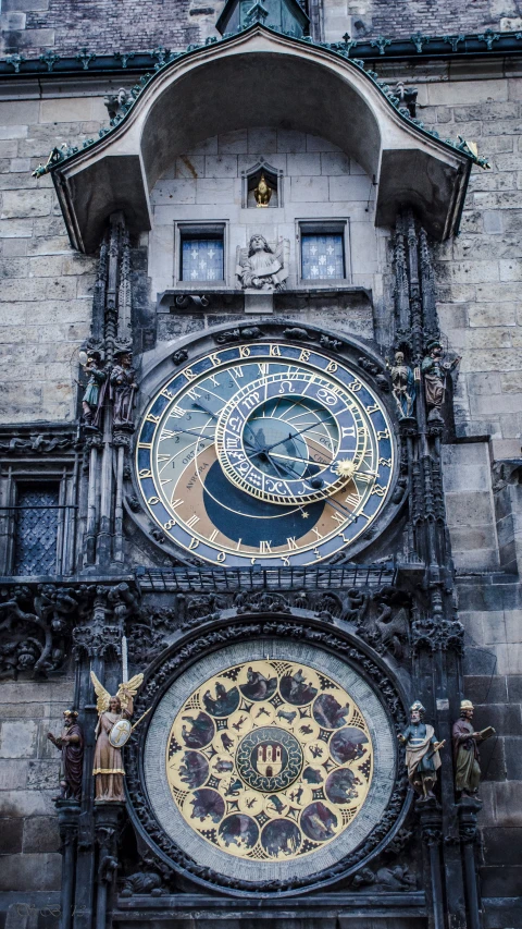 two clocks are on the side of an old building