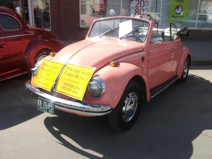 this is a pink car parked in the street