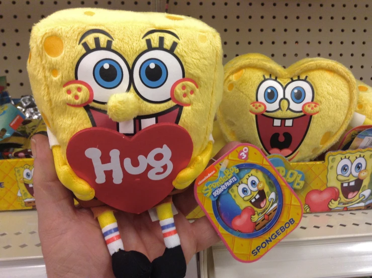 the hand is holding two spongebobs and a heart - shaped object