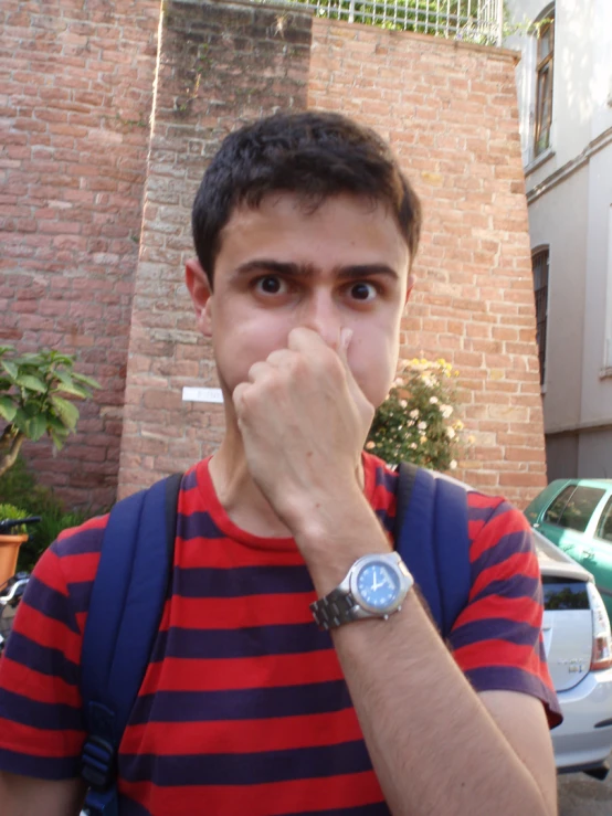 man looking up with hands covering mouth outside