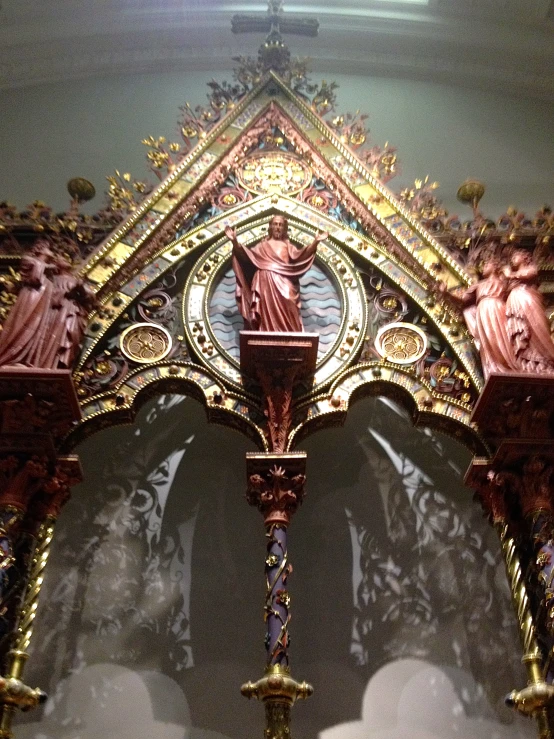 a church alter with gold and red decorations on it