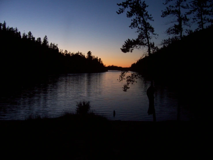 the man looks out across the water to see the setting sun