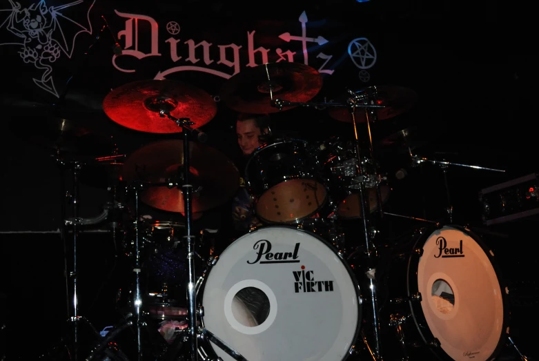 a concert with drum kit and sign in background