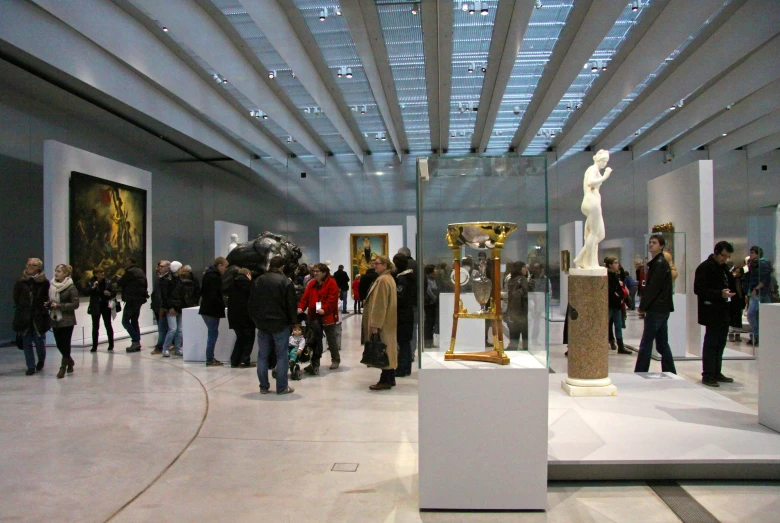 the interior of an art gallery shows a marble sculpture and paintings on display