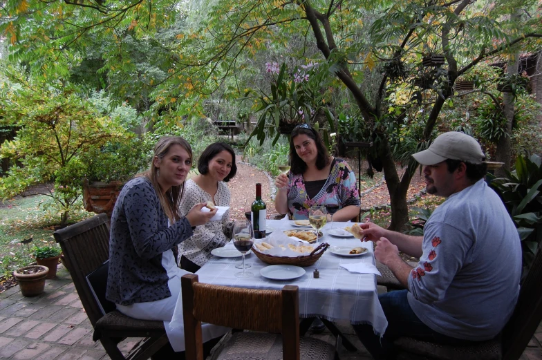 a group of people sitting at a table outdoors