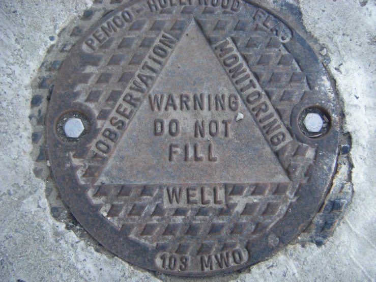 the manhole cover has a warning sign in it