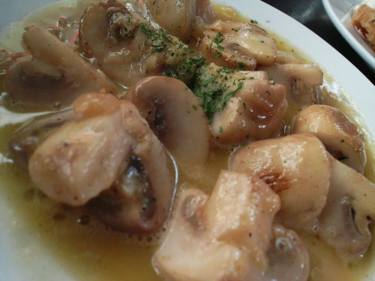 close up view of meat and mushrooms in a broth