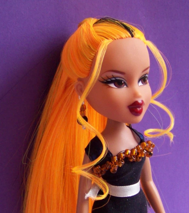 a doll with long hair wearing an orange and black dress