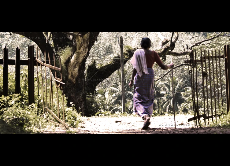 an old man is walking down a path through the woods