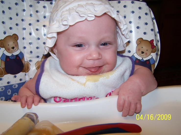 a small baby sits in her highchair eating food