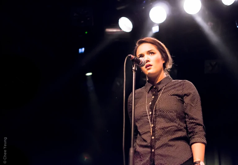 a girl standing in front of a microphone