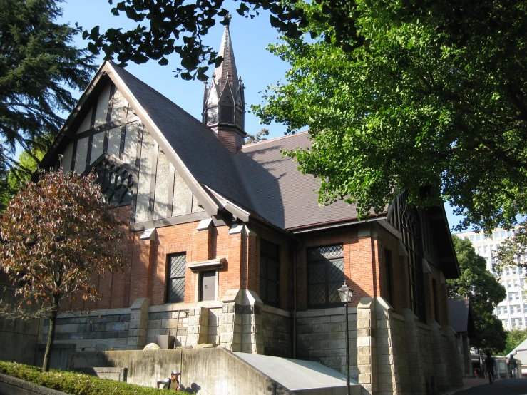 an old church with a steeple next to some trees