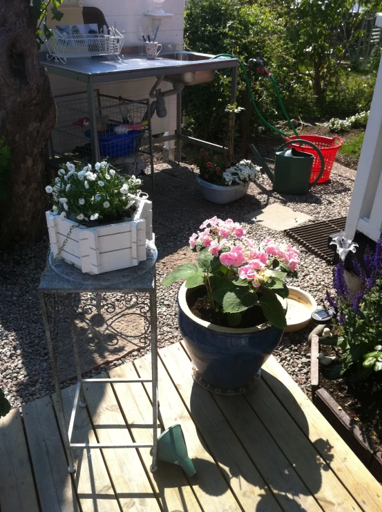 a small wooden deck with flowers in the middle of the yard