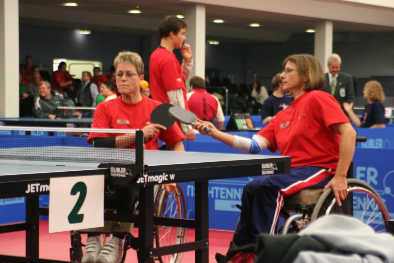 a ping pong table full of people waiting for the ball to be served